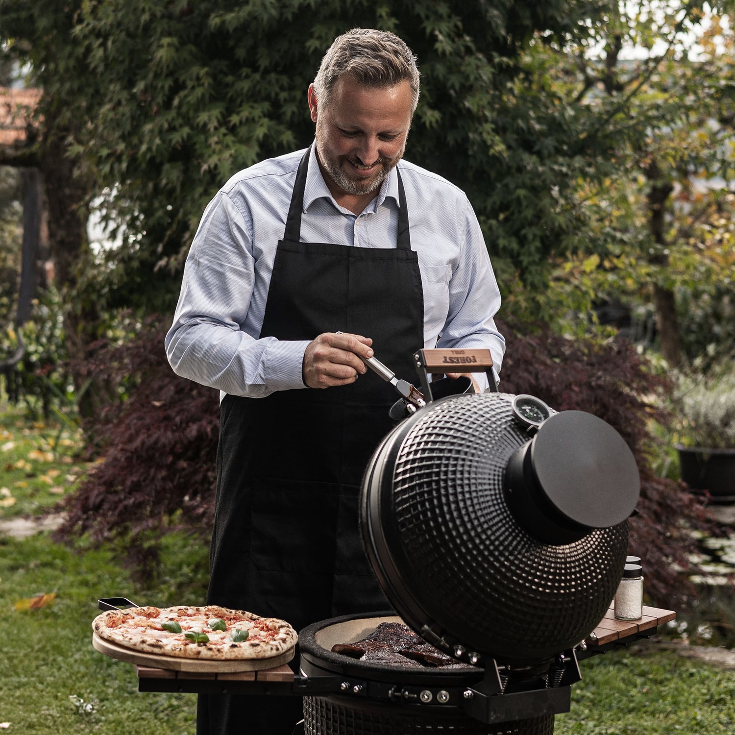 Moment convivial autour du barbecue Forest Grill, combinant puissance, précision et plaisir pour des cuissons parfaites en extérieur.
