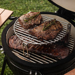 Steaks juteux et côtes marinées grillés sur le barbecue Forest Grill, grâce à la grille d’extension en inox offrant une cuisson à plusieurs niveaux.