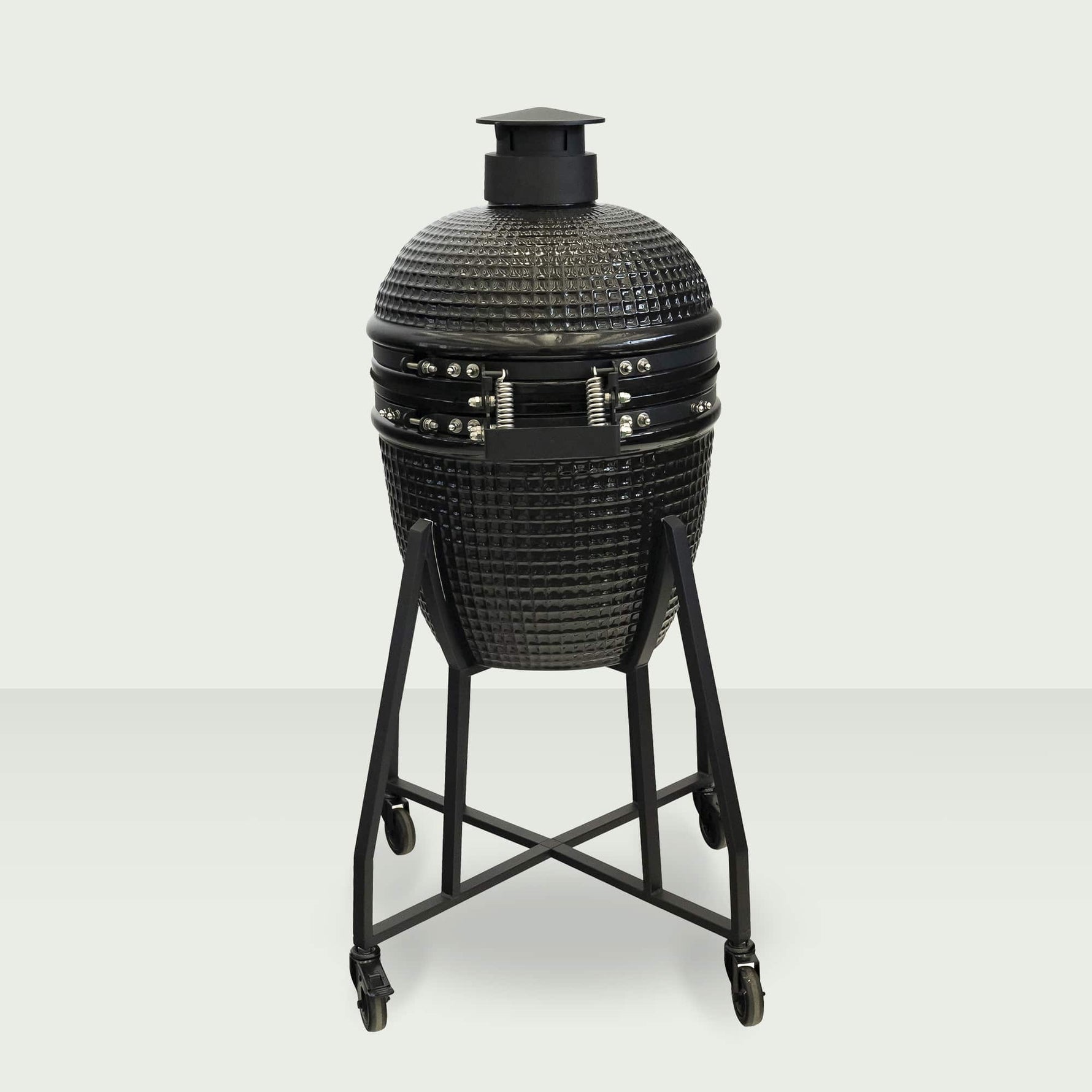 Barbecue Kamado 18" fermé, monté sur un chariot en acier avec roulettes, affichant un design robuste et compact.