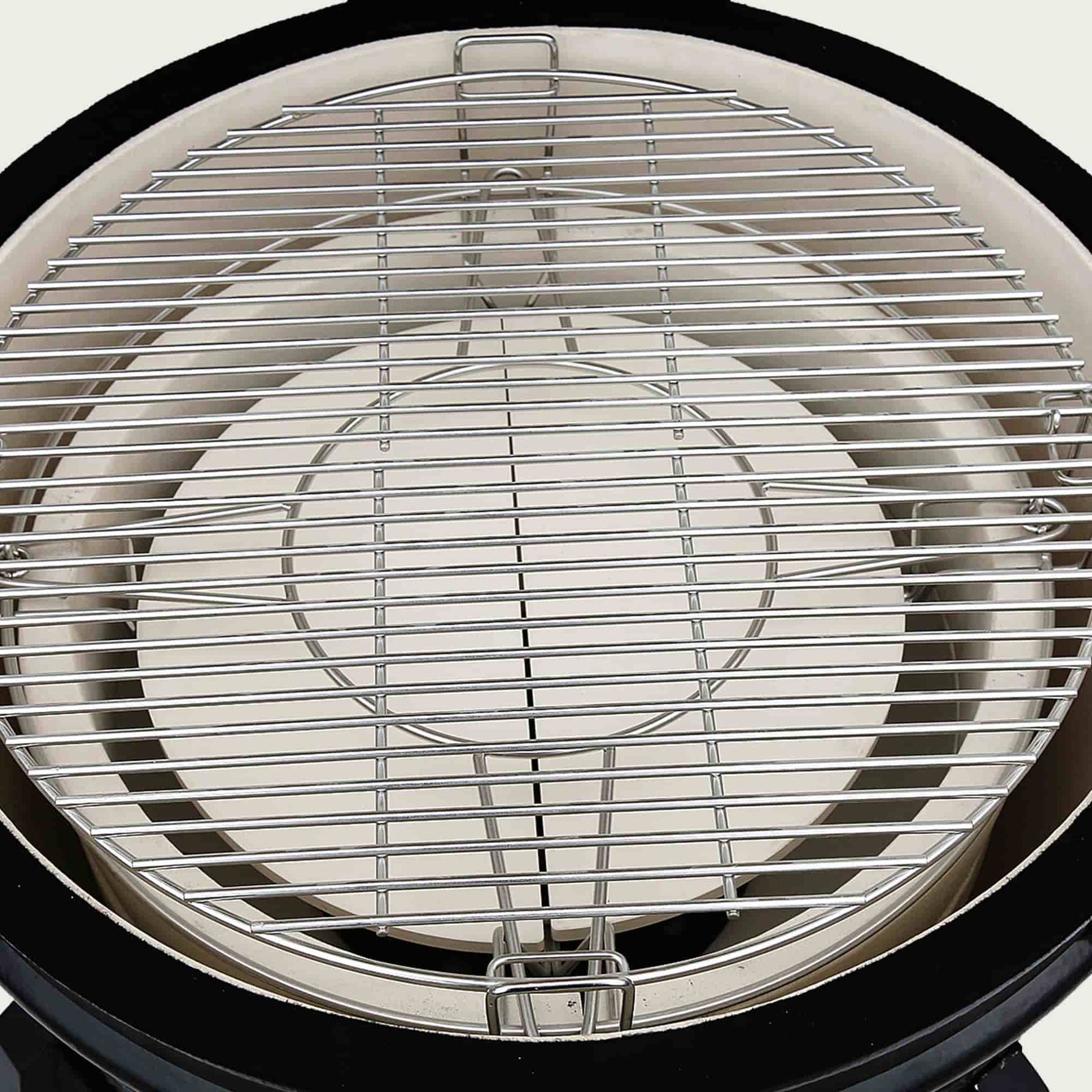 Vue intérieure du Kamado Forest Grill équipée d’une grille de cuisson en inox massif et d’une pierre déflectrice en céramique épaisse, idéale pour la cuisson indirecte.