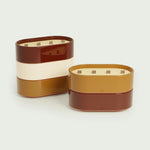 Bougies Totem L Forest en Rouge oxyde et Brun terre de sienne, parfums Citronnelle & Géranium et Citronnelle & Fleur d’oranger, avec mèches en bois et finitions brillantes pour une ambiance chaleureuse.