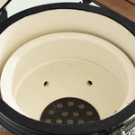Intérieur d’un barbecue Kamado vide, montrant l’épaisseur de la céramique et la plaque perforée au fond pour une meilleure circulation de l’air et résistance à la chaleur.