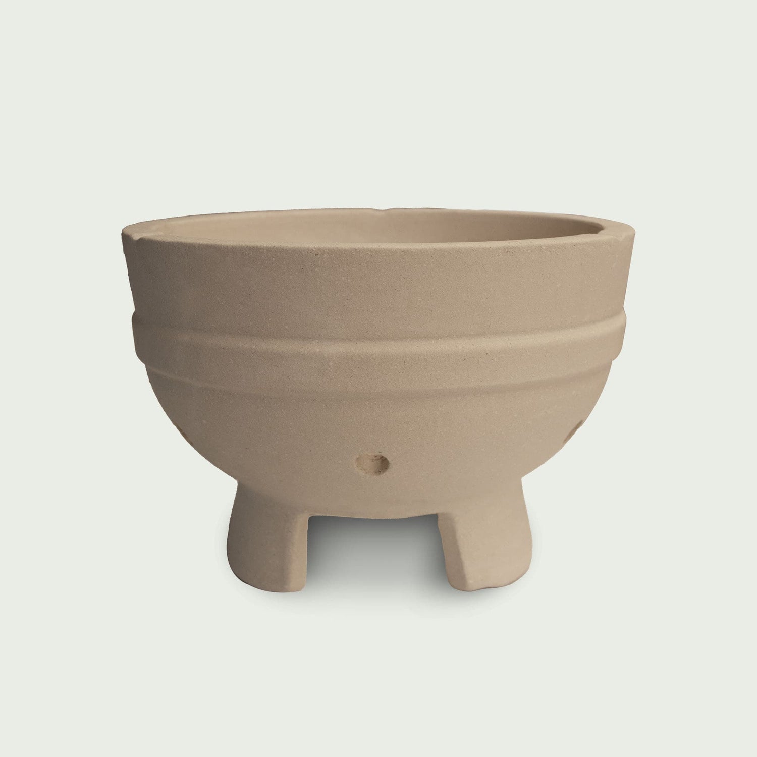Cuve en céramique beige pour kamado, avec pieds intégrés et orifices d’aération, conçue pour accueillir le foyer et assurer une bonne circulation de l’air.