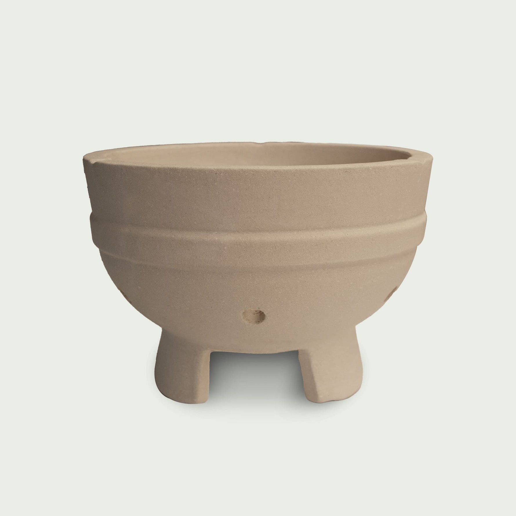 Cuve en céramique beige pour kamado, avec pieds intégrés et orifices d’aération, conçue pour accueillir le foyer et assurer une bonne circulation de l’air.