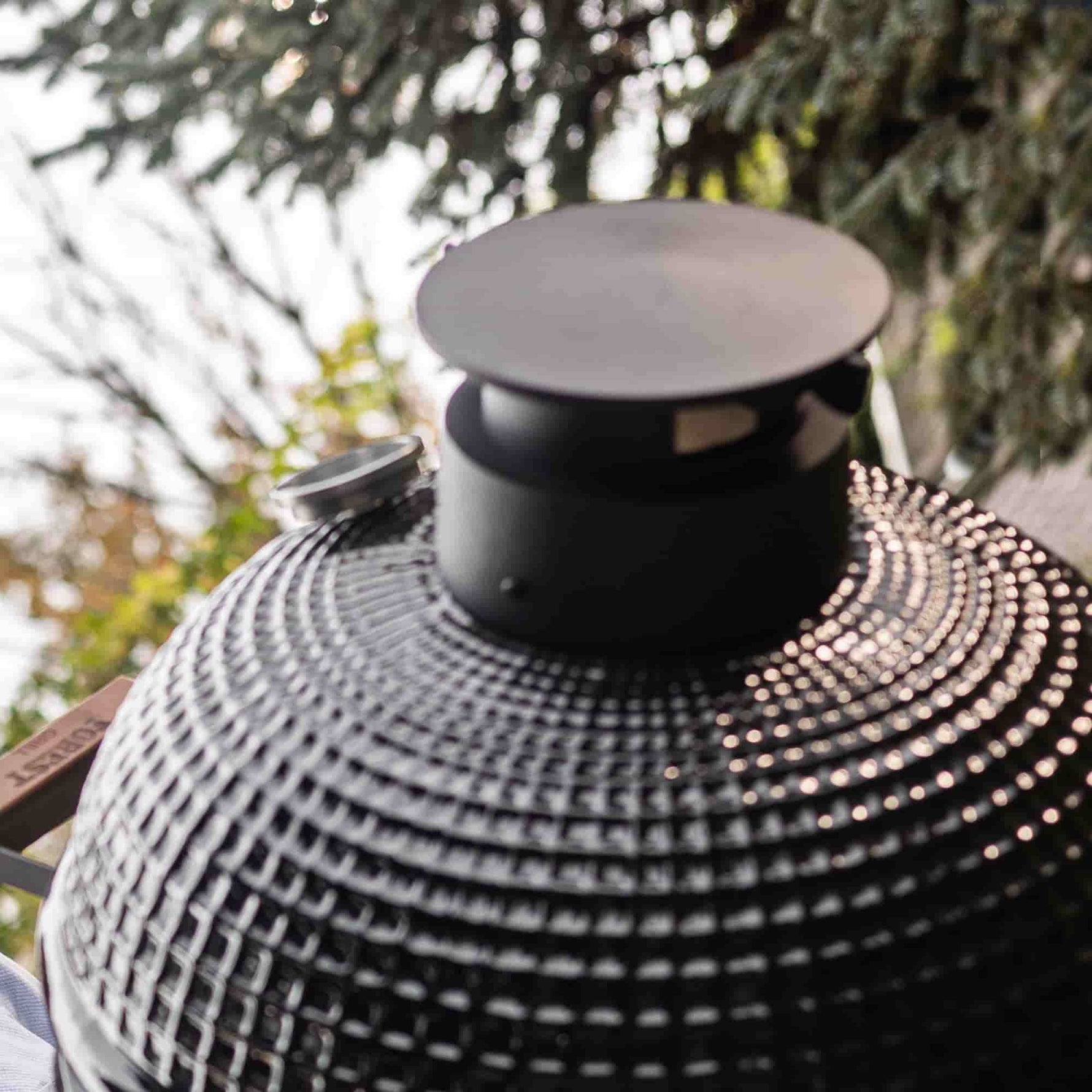 Détail du couvercle du barbecue Kamado Forest Grill avec sortie d’air réglable en fonte, illustrant la finition extérieure en céramique texturée.