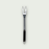 Fourchette à viande en acier inoxydable avec manche noir ergonomique et embout perforé pour suspension.