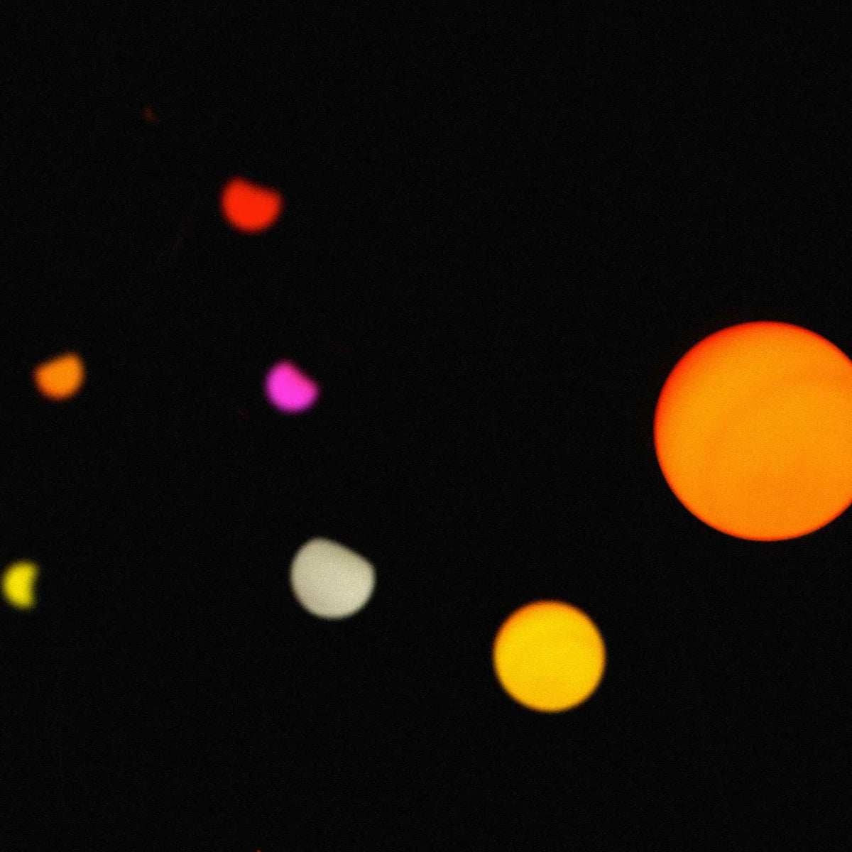 Guirlande lumineuse Forest Grill Sunset allumée de nuit, diffusant des tons chauds et colorés — jaune, orange, rose et violet — créant une atmosphère douce et festive idéale pour les soirées extérieures.