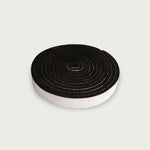 Rouleau de joint en feutre noir pour kamado, présenté en spirale sur fond clair.