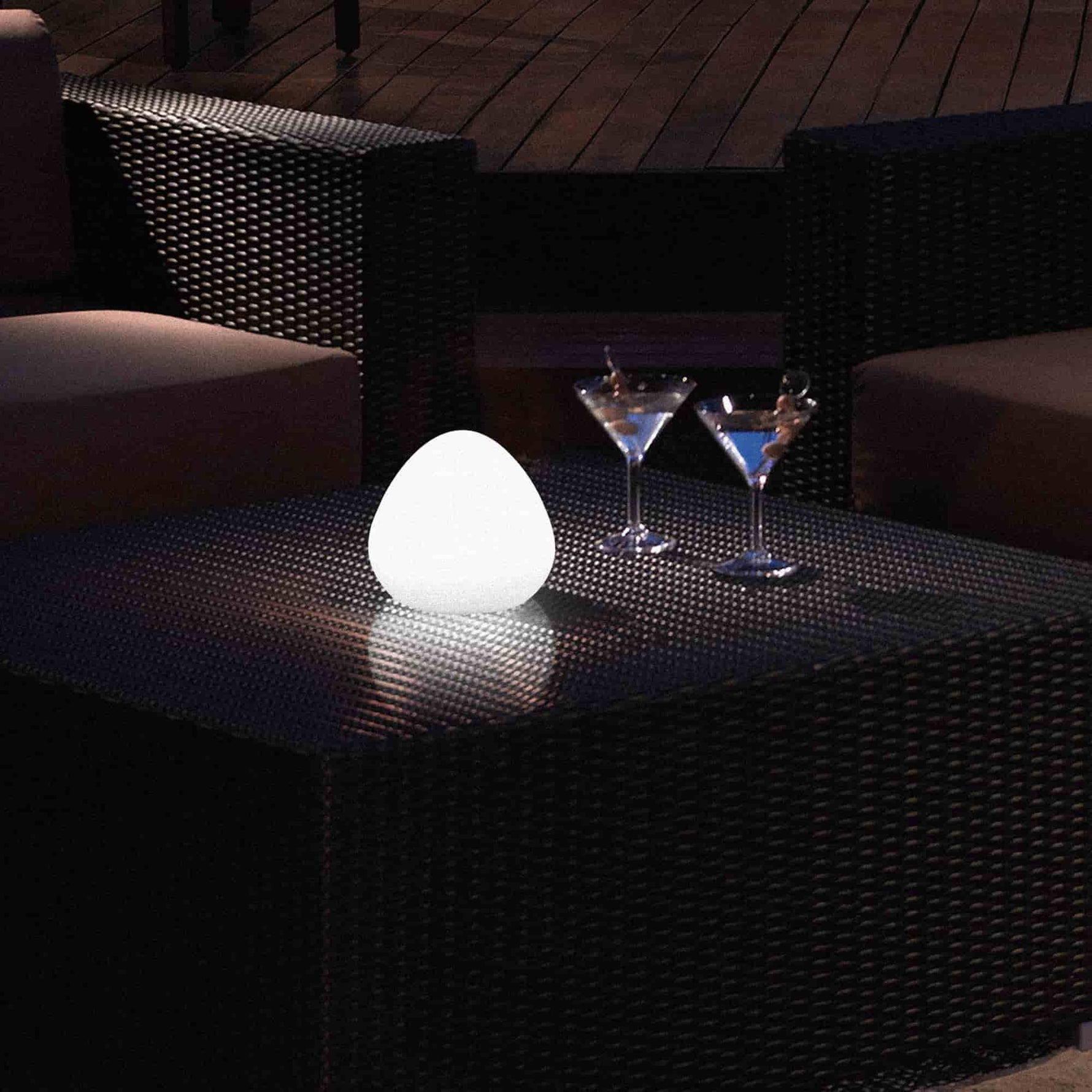 Lampe d’extérieur Noisette Forest Grill posée sur une table de jardin en soirée, diffusant une lumière blanche douce et apaisante pour une ambiance élégante et conviviale.
