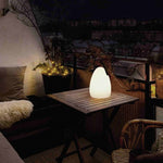 Lampe d’extérieur Œuf Forest Grill posée sur une table de balcon, diffusant une lumière chaude et apaisante pour une ambiance cocooning en soirée.