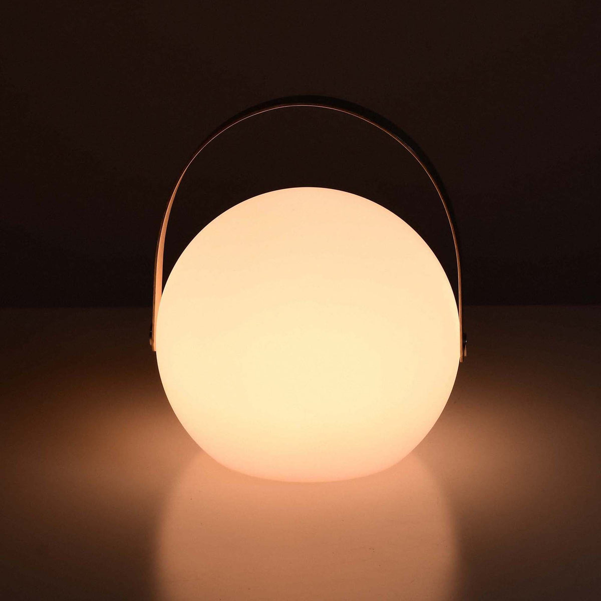 Lampe d’extérieur ronde Forest Grill allumée, diffusant une lumière chaude et apaisante à travers son globe blanc mat.