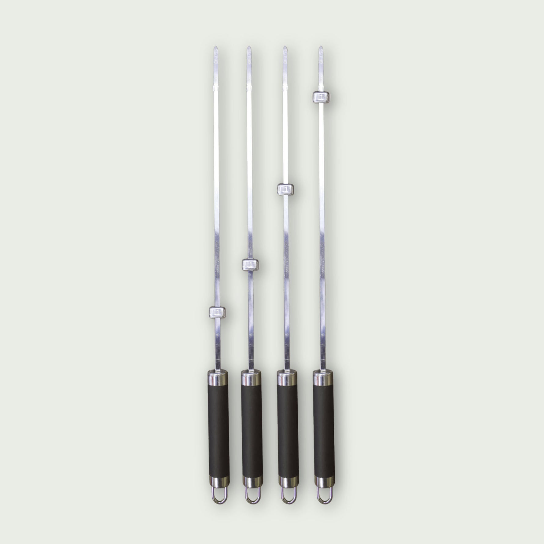 Ensemble de quatre brochettes en acier inoxydable avec manche noir et bague de serrage réglable pour maintenir les aliments.