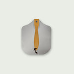 Pelle à pizza vue de dessus, avec manche court en bois clair et cordelette noire, posée à plat pour mettre en valeur sa forme arrondie et sa surface lisse.