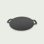 Plaque de cuisson en fonte vue de côté, mettant en avant son épaisseur robuste et ses poignées latérales pratiques pour une manipulation facile sur le barbecue.