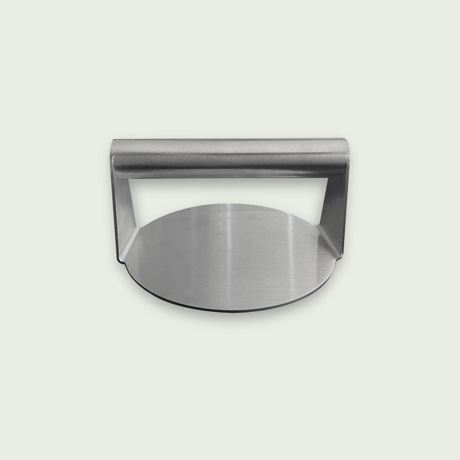 Presse à burger en acier inoxydable avec poignée intégrée, présentée sur fond clair, de face, idéale pour aplatir et cuire uniformément les steaks sur plancha ou barbecue.