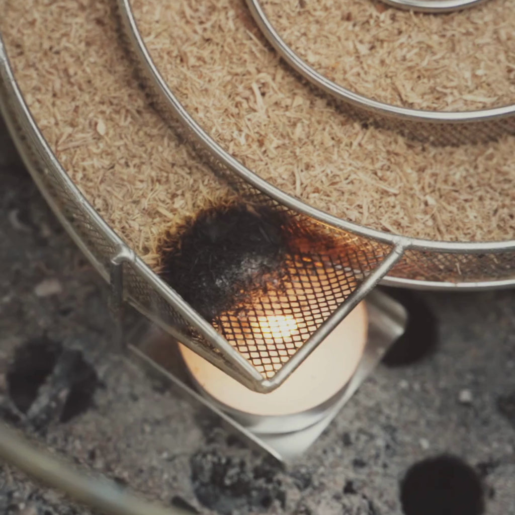 Vidéo présentant un serpentin de fumage en métal rempli de sciure, destiné au fumage à froid dans un kamado forest grill. On y voit l’accessoire sous différents angles et en fonctionnement, avec la sciure qui se consume progressivement.