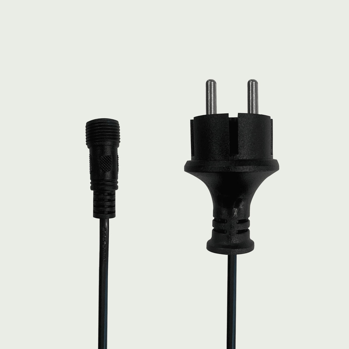 Câble de rallonge pour guirlande lumineuse extérieure, présentant une prise mâle à deux broches et un connecteur étanche à visser, sur fond clair.